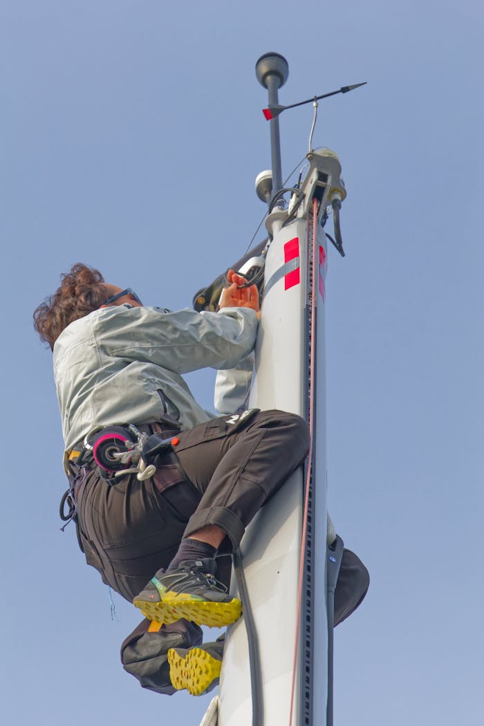 about-us-01 A skilled technician climbing a mast in Les Sables-d'Olonne, showcasing expertise in sailing technology.